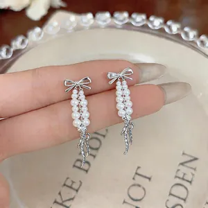 Dettaglio ravvicinato di eleganti orecchini a fiocco francese con perle a cascata