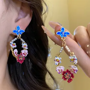 Close-up of vintage floral earrings with pearls, crystals and colorful enamel