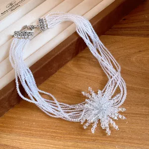Dettaglio della collana di perle di cristallo sfaccettate a più strati con ciondolo