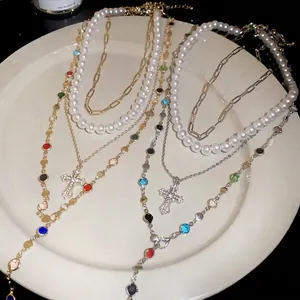 Layered Y-shaped necklace with pearls, rhinestones and cross pendants in gold and silver