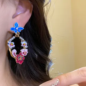Vintage style floral drop earrings with pearls and colorful enamel flowers.
