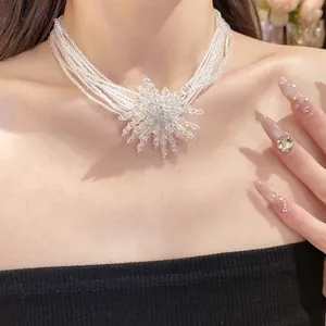 Dettaglio di una collana a più strati di perle di cristallo trasparente con ciondolo