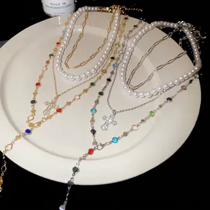Multi-layer pearl necklace with colorful resin stones and a sparkly cross pendant.