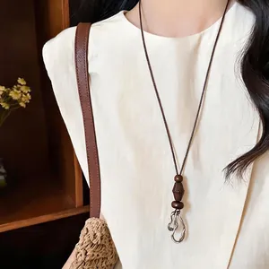 Minimalist bohemian ethnic style necklace featuring wooden beads and a silver pendant
