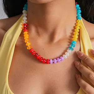 Close-up of a vibrant colorful acrylic beaded necklace on a model's neck.