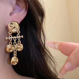 Detailed macro view of vintage gold metallic wrinkled pendant earrings with texture