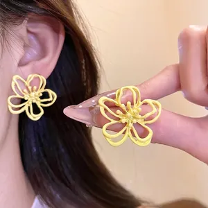 Elegantes pendientes de flor amarilla calada con un estilo de resort fresco y dulce