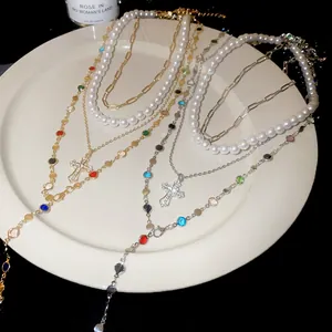 Close-up of multi-layer Y-shaped necklace with pearls, rhinestones, and cross pendant