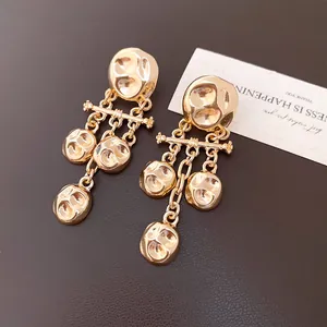 Macro view showing the detailed hammered metal texture of the gold drop earrings