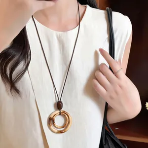 Close-up view of a Bohemian bamboo-style double-ring pendant necklace worn by a model