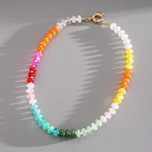 Vibrant multi-color acrylic beaded necklace with gold spring clasp on grey texture