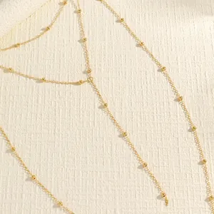 Detailed macro shot of vintage gold double-layer beaded body chain jewelry accessory