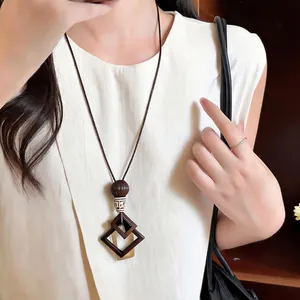 Detailed view of a bohemian ethnic style long necklace with geometric square pendants