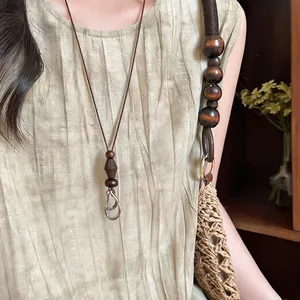 Close-up of a Bohemian ethnic necklace featuring dark wooden beads and metal ring