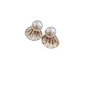 Elegant shell-shaped stud earrings with round white pearls and a luxury gold-tone finish
