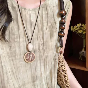 Detailed view of a Bohemian style ethnic woven pendant necklace with a mesh design
