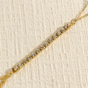 Close-up detail of a vintage gold-tone body chain with sparkling clear rhinestones