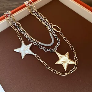 Dettaglio di una collana metallica multistrato con ciondoli a stella oro e argento