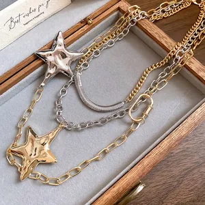 Dettaglio della collana multistrato con stelle in tonalità oro e argento.