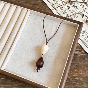 Detailed view of bohemian teardrop pendant on a wooden jewelry tray