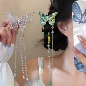 Gros plan d'une pince à cheveux papillon brodée élégante avec de longs glands perlés.