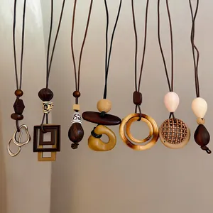 Detailed macro view of bohemian ethnic style long pendant necklaces with wooden beads