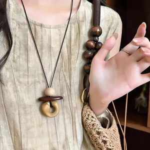Bohemian wood bead necklace with stone-like pendant detail on model.
