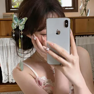 Vue détaillée d'une pince à cheveux papillon brodée avec glands verts sur modèle