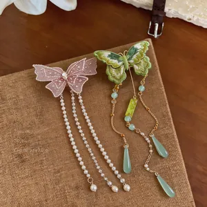 Gros plan des pinces à cheveux papillon brodées avec pompons de perles élégants