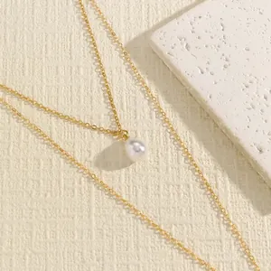 Detail shot of a vintage gold double-layer body chain with a water-drop pearl pendant.