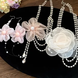 Detail of elegant chiffon flower necklaces and earrings with rhinestones and tassels