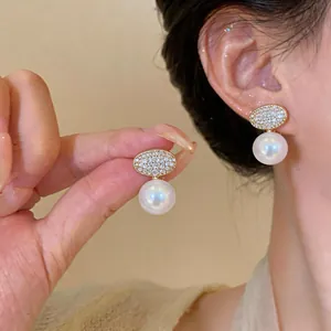 Elegant French style zircon oval pearl clip-on earrings shown worn on a model's ear