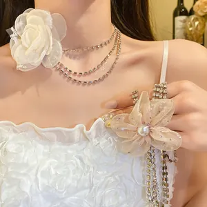 Close-up of rhinestone choker necklace featuring elegant chiffon flowers and tassels.