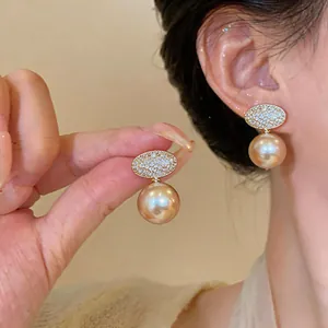 Close-up detail of elegant champagne pearl clip-on earrings with pavé zircons.