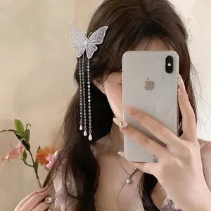 Vue détaillée d'une pince à cheveux papillon brodée avec de longs glands élégants