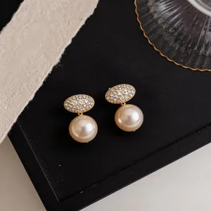 Close-up detail of elegant French oval zircon and pearl clip-on earrings.