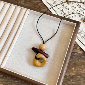 Bohemian ethnic necklace with geometric wood pendants and a minimalist choker cord