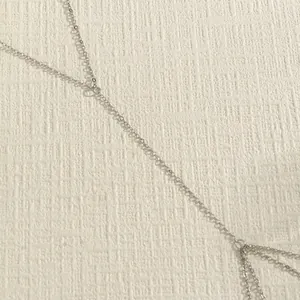 Close-up of minimalist silver double-layer body chain detail with fine links.