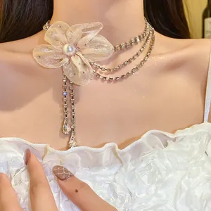 Close-up of elegant champagne chiffon flower choker with sparkling rhinestone tassels