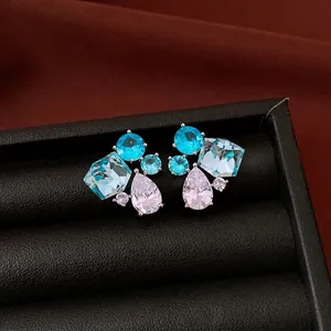 Vintage silver needle teardrop stud earrings with blue and clear cubic zirconia stones.