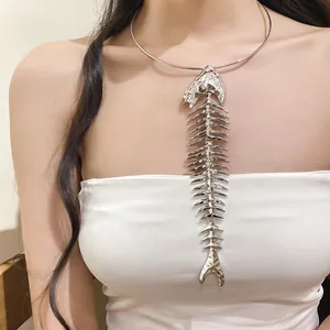 Detail view of a silver oversized fishbone pendant choker necklace on a female model