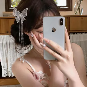 Détails d'une élégante pince à cheveux papillon brodée avec des glands de perles.