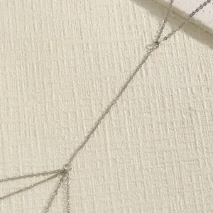 Detail view of simple silver body chain with minimalist retro link design