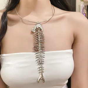 Detailed shot of an exaggerated silver fishbone pendant necklace worn as jewelry.