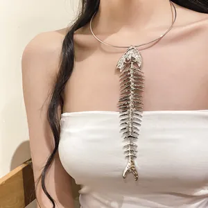 Close-up detail of an exaggerated silver metallic fish bone statement necklace on model.