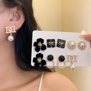 Elegant 5-pair vintage earring set with pearls and black floral studs on a card.