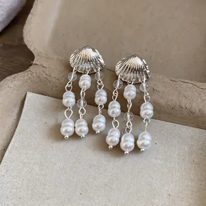 Gros plan de boucles d'oreilles élégantes à pampilles en nacre et perles argent