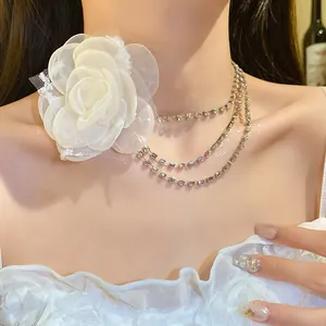 Detail of elegant white chiffon flower choker with three-tier sparkling rhinestone chains.