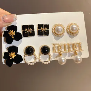 Detailed view of vintage French style pearl and velvet flower earring set on white card