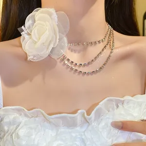 Close-up of elegant rhinestone choker necklace with a large white chiffon flower.